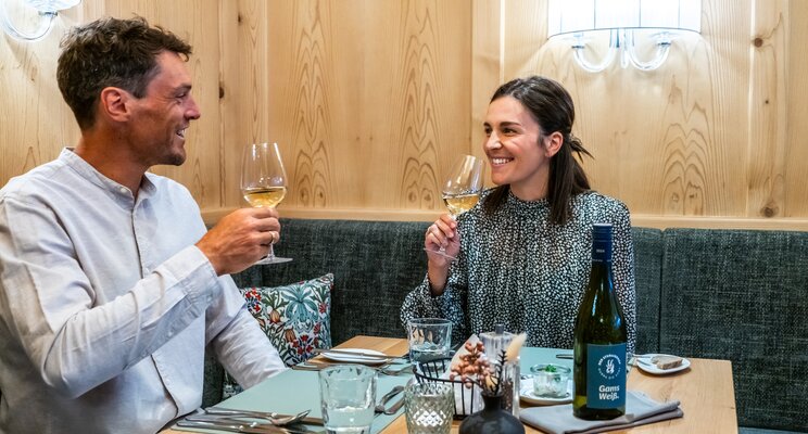Lächelndes Paar beim Weißweingenuss im Restaurant