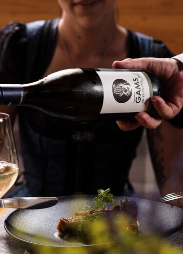 Kellner schenkt Weißwein zu Speise ein