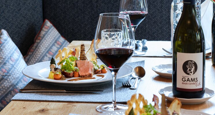 Gedeckter Tisch mit Speisen, Weingläsern und Besteck