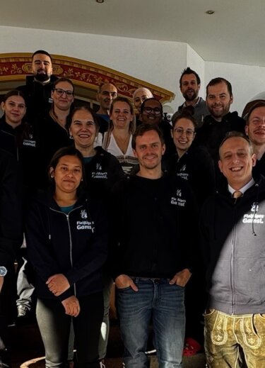 Teamfoto auf der Treppe vor dem Hoteleingang