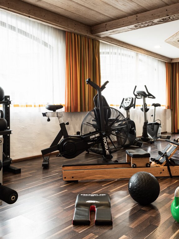 Fitness room with dumbbells, training equipment and large windows