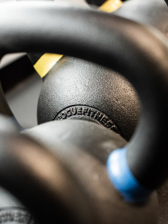 Close-up of black kettlebells with Rogue Fitness inscription
