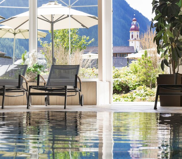 Pool mit Liegen, Blick auf Kirche und Berge