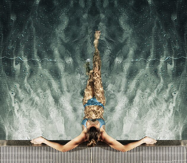 Frau im Pool, von oben fotografiert, Hände am Beckenrand, Wasser spiegelt sich