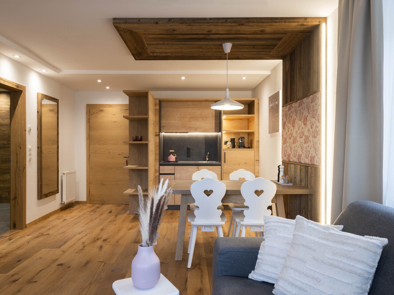 Bright apartment with wooden elements, dining table and kitchenette