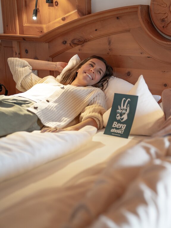 Lächelnde Frau entspannt in rustikalem Holzbett