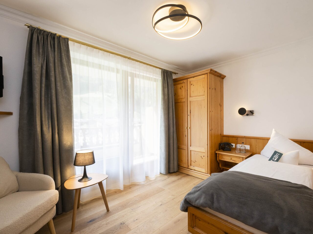 Gemütliches Hotelzimmer "Elferspitz" mit Bett und Holzmöbeln