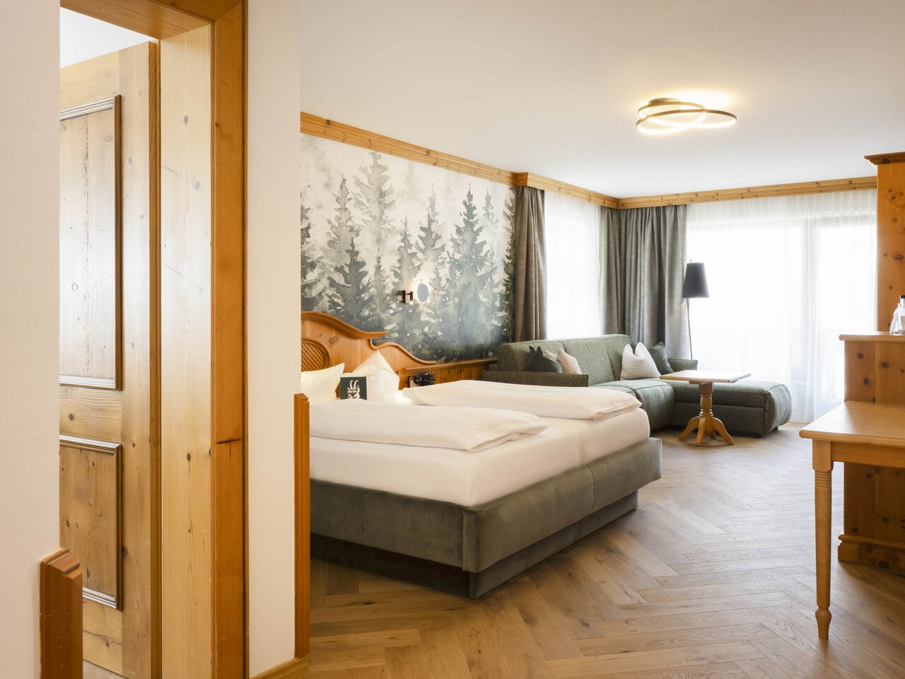 Modernes Hotelzimmer "Familienglück" mit Doppelbett und Waldbild