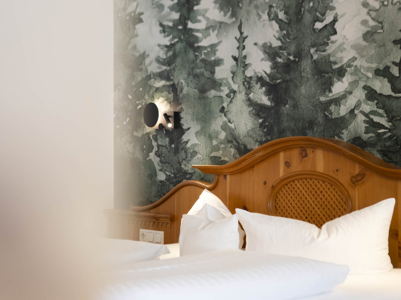 Cozy wooden bed with forest-themed wallpaper