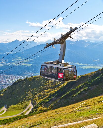 Nordkettenbahn-Gondel auf Bergspitze mit Blick auf Innsbruck und Alpenpanorama