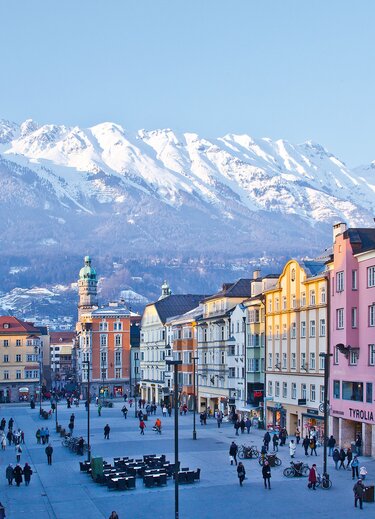 Innsbruck&#39;s old town with colorful houses and snow-capped mountains in the background