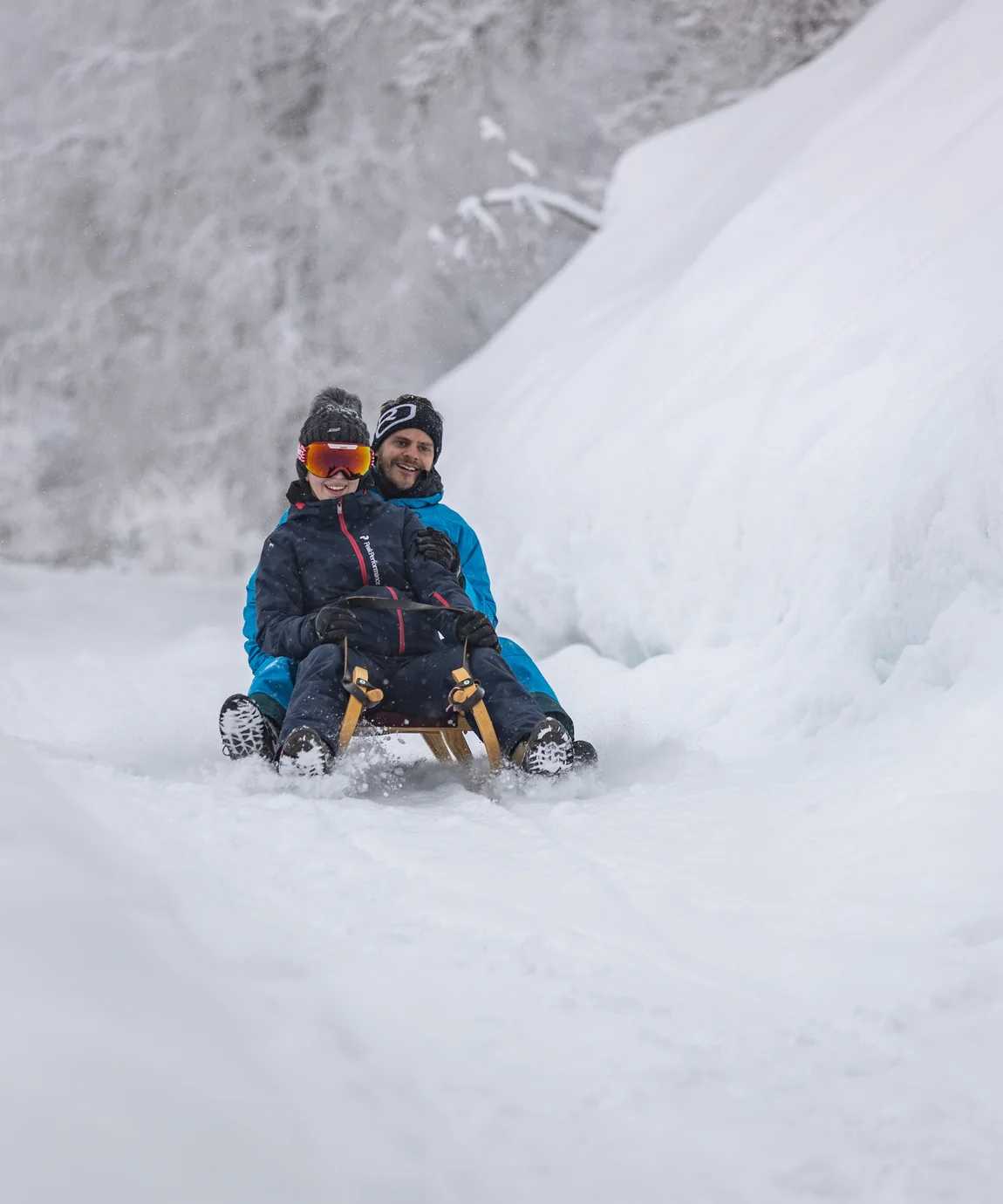 Two people sledding in the snow