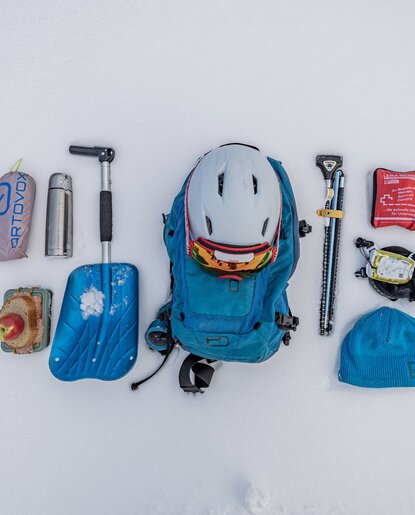 Equipment for ski touring on snow: backpack, helmet, shovel, probe, thermos, first aid kit